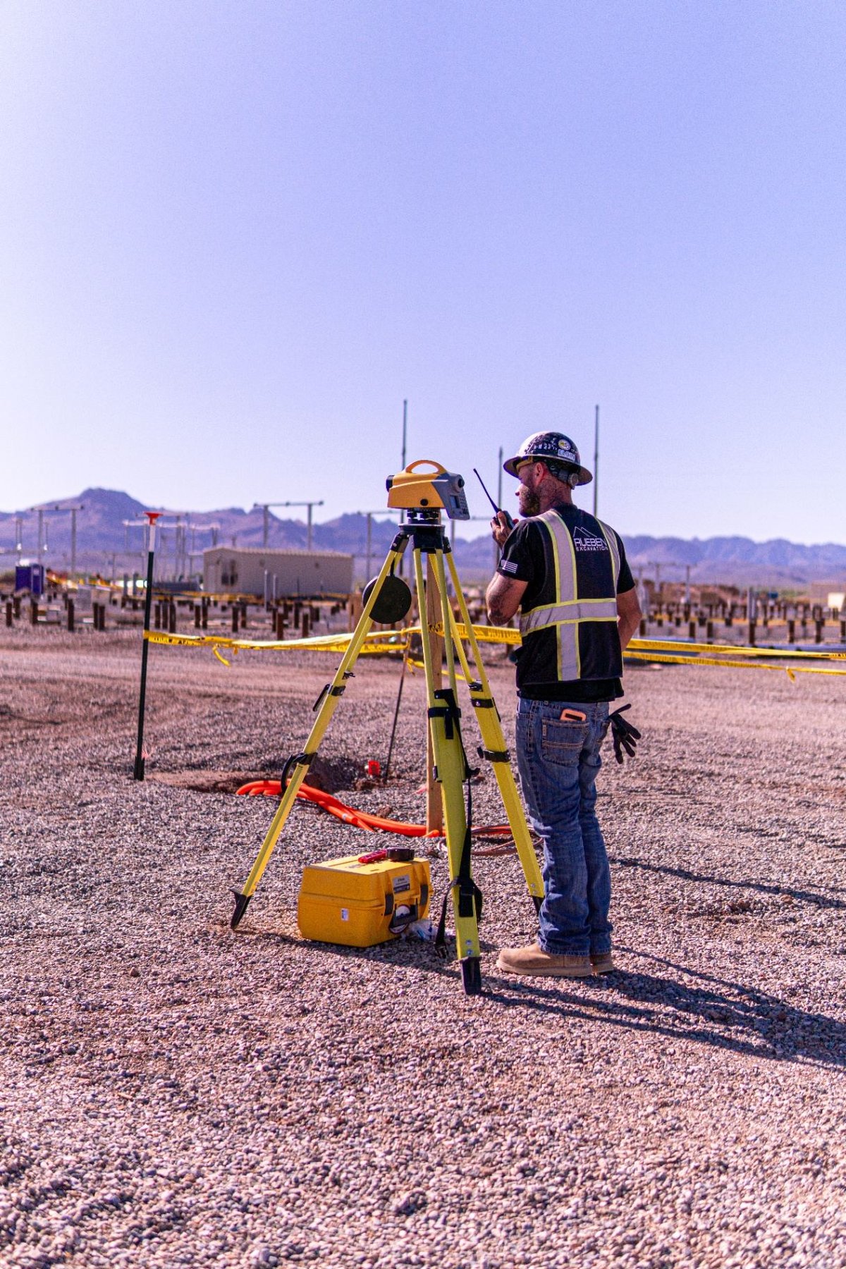 Rueben Excavation surveyor with total station tripod verifying pile layout on a BESS site