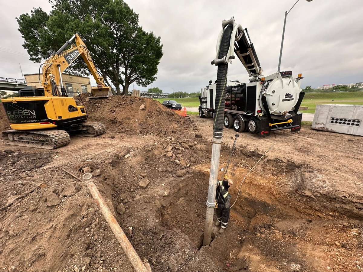 Rueben Excavation hydrovac truck and excavator daylighting utilities on a DFW jobsite