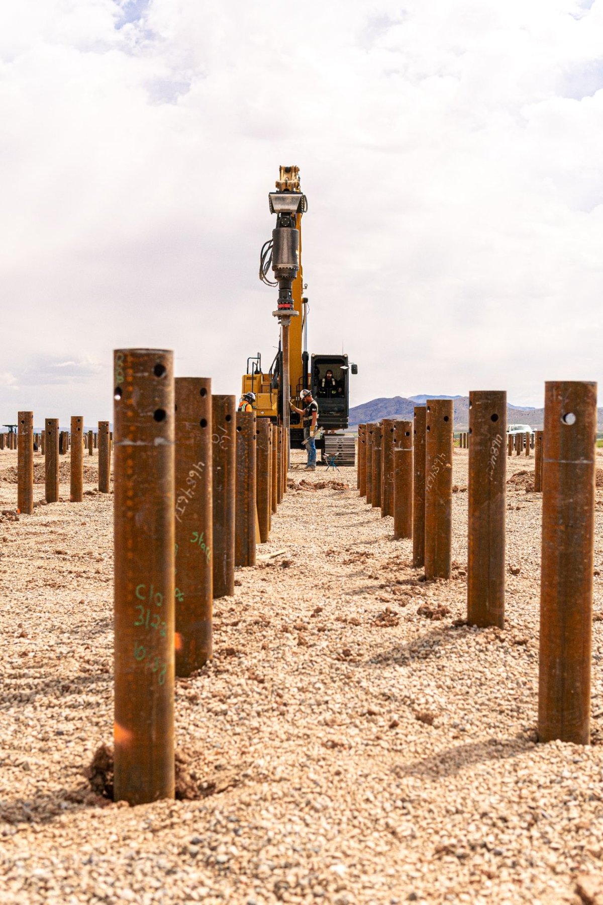 Rueben Excavation drilling rig installing pile foundations across a utility-scale pile array