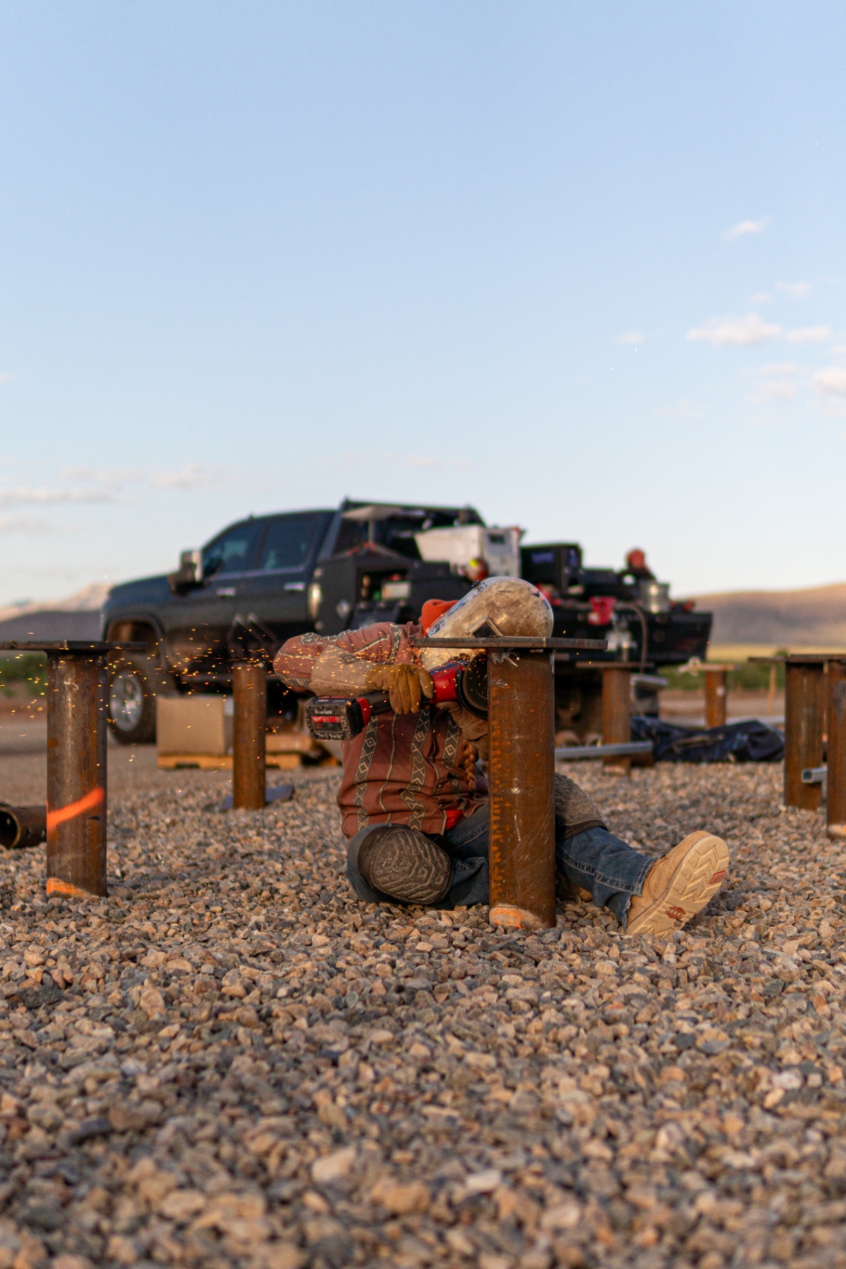 Field crew member grinding a pile cap connection at a foundation location