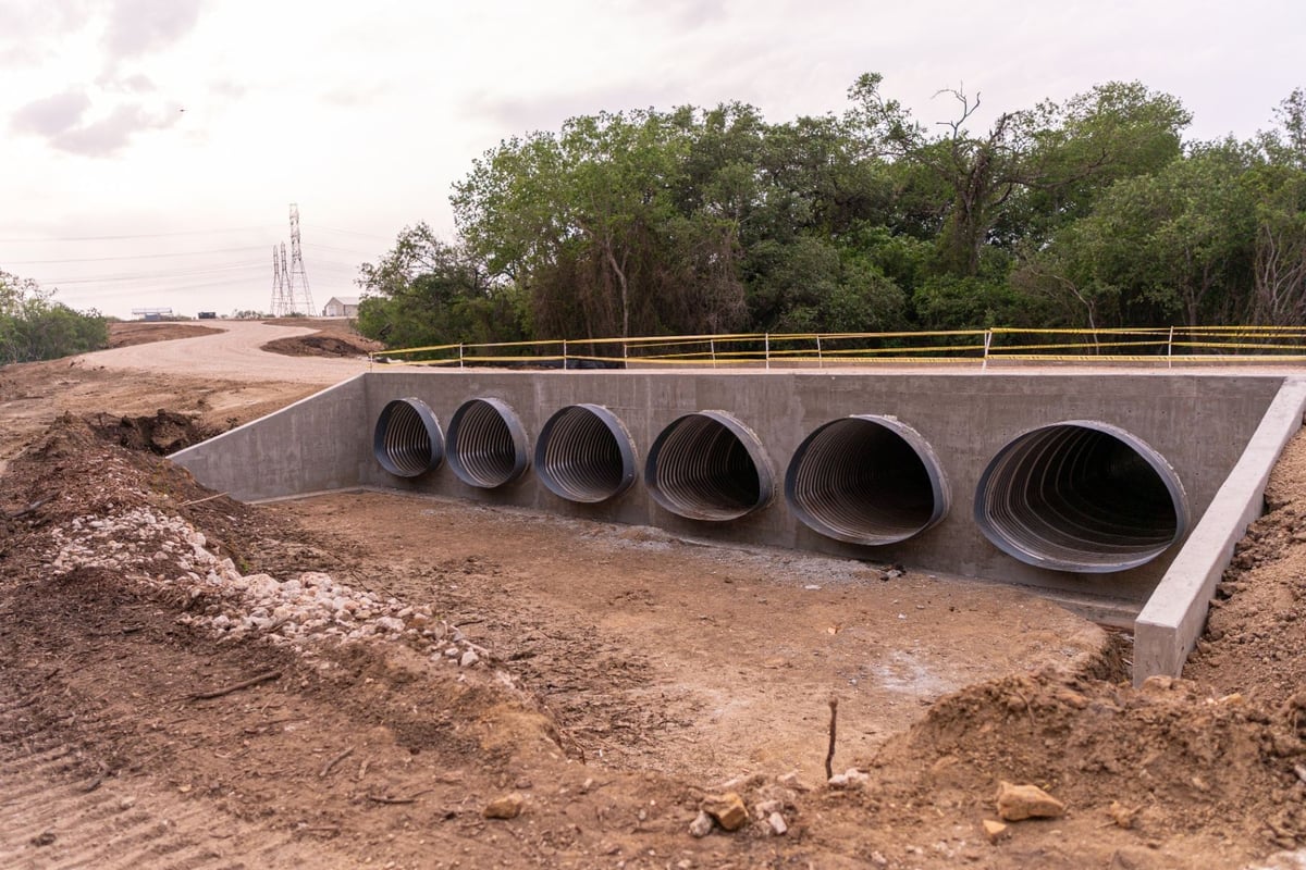 Multi-barrel corrugated metal pipe culvert with concrete headwall on access road crossing