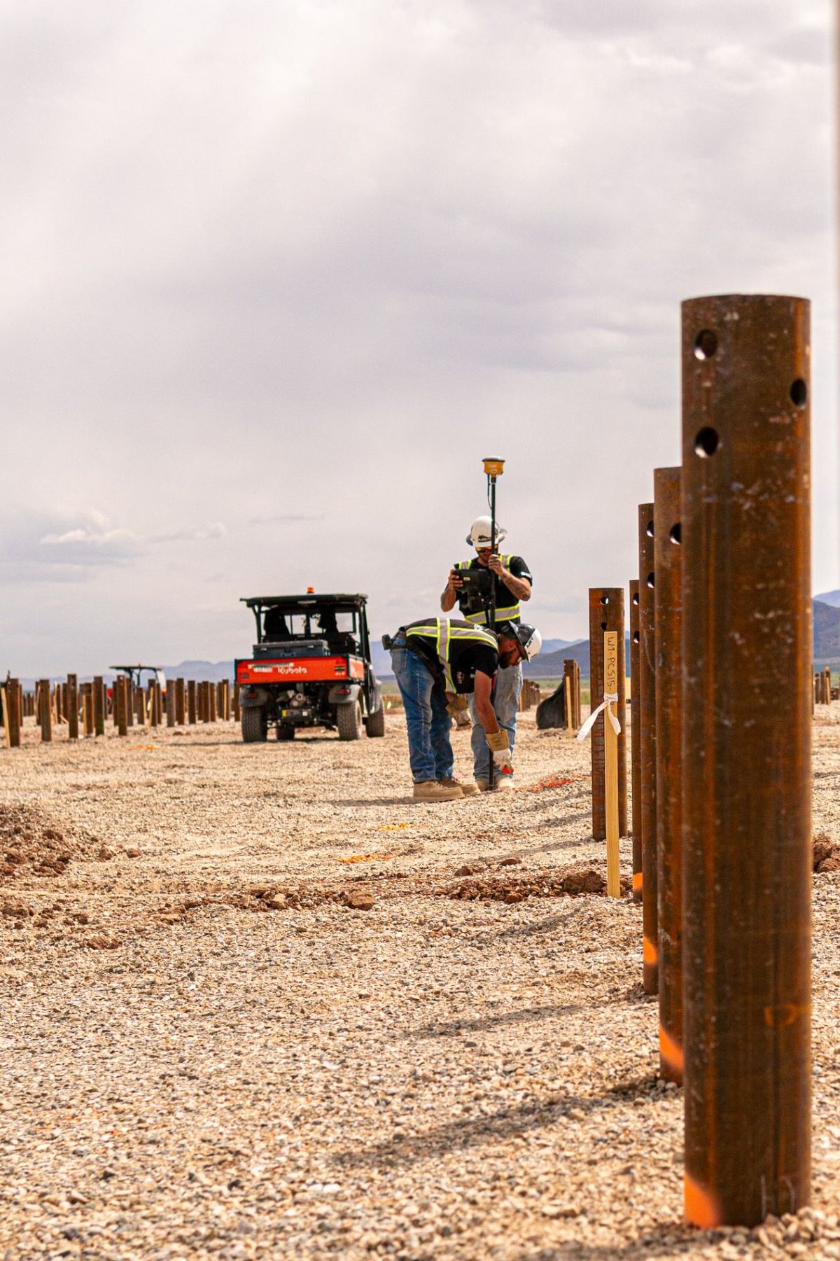 Rueben Excavation survey crew verifying pile locations with GPS rover along installed pile row