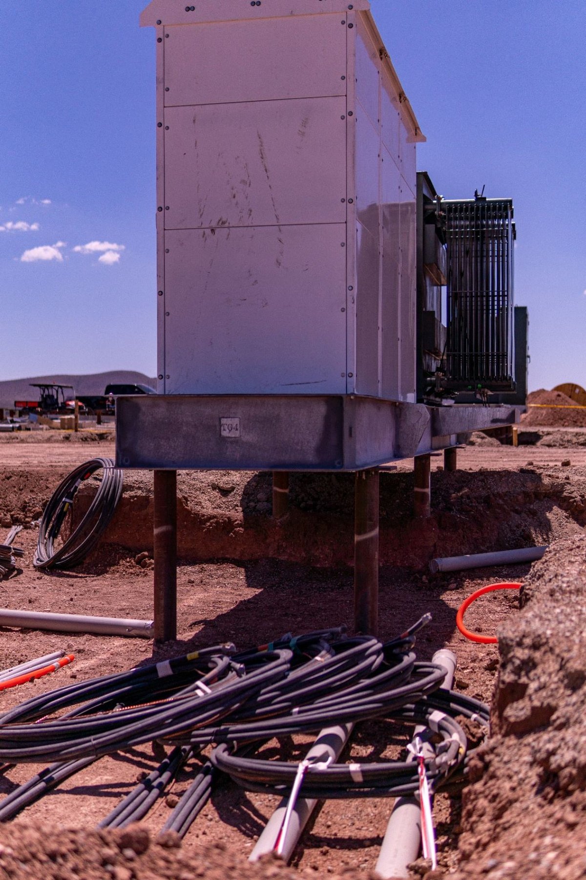 Fabricated steel pile cap supporting BESS equipment with cable trench below