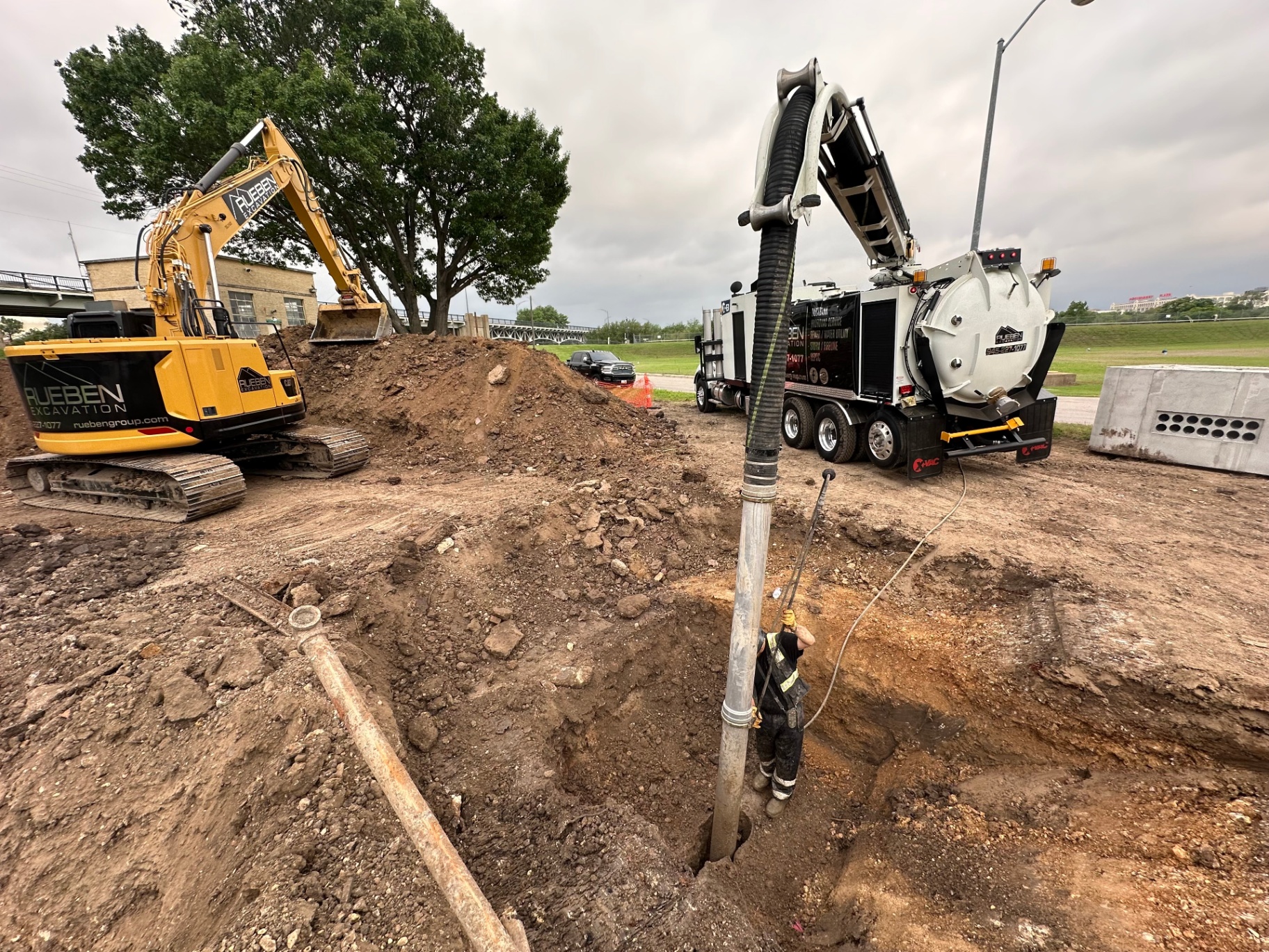 Rueben Excavation hydrovac truck and excavator daylighting utilities on a DFW jobsite