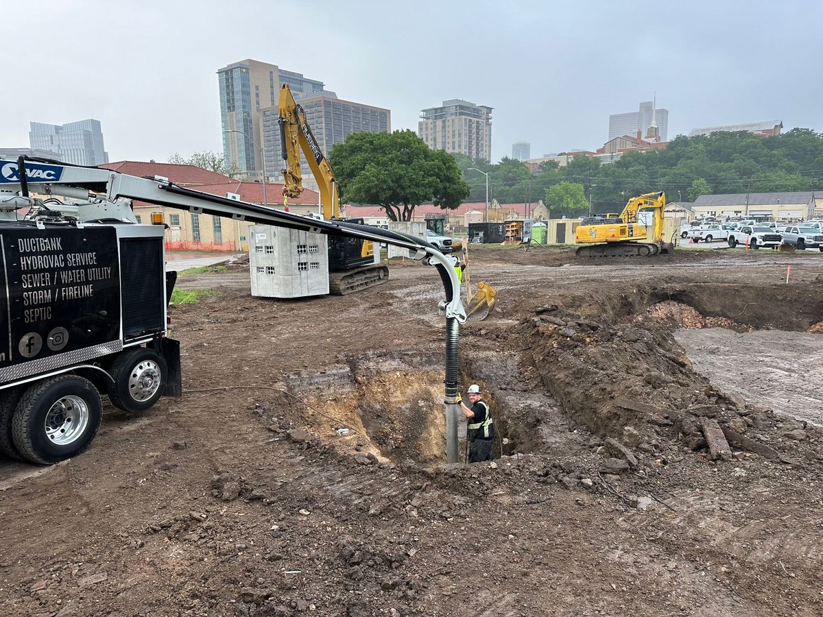 Hydrovac boom potholing near precast structures on a downtown construction site