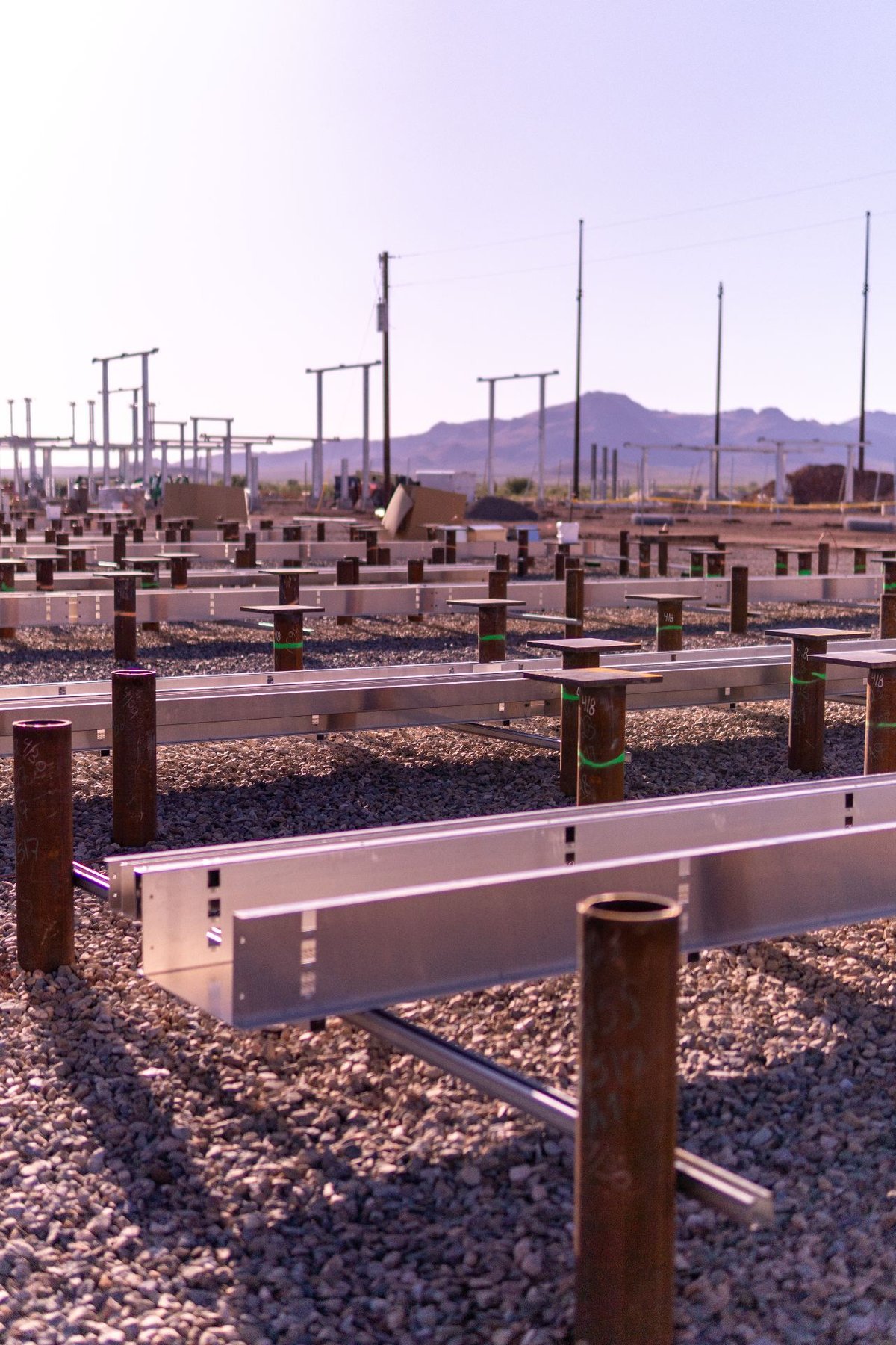 Pile foundation array with cable tray and equipment supports installed on utility-scale desert site