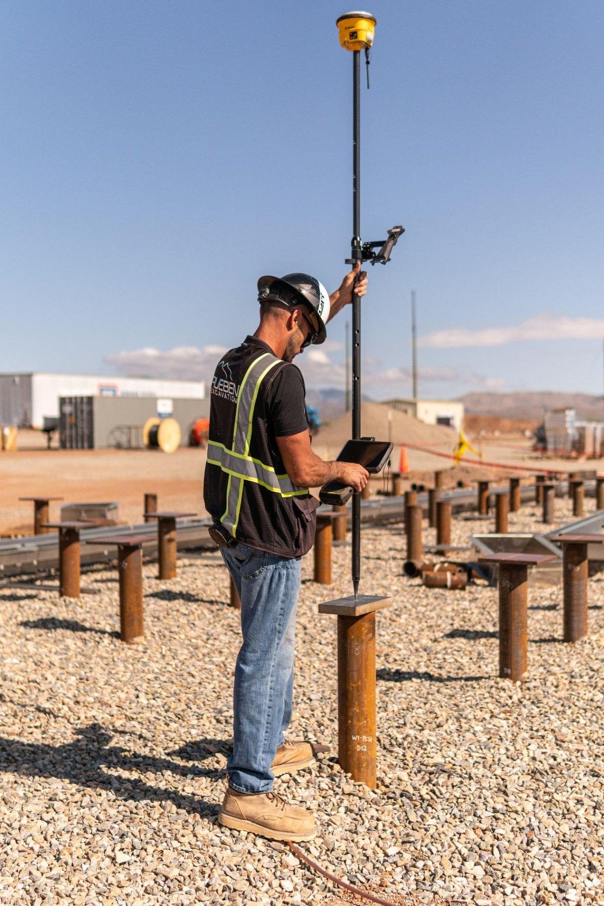 Survey crew verifying installed pile cap elevation with GPS rover