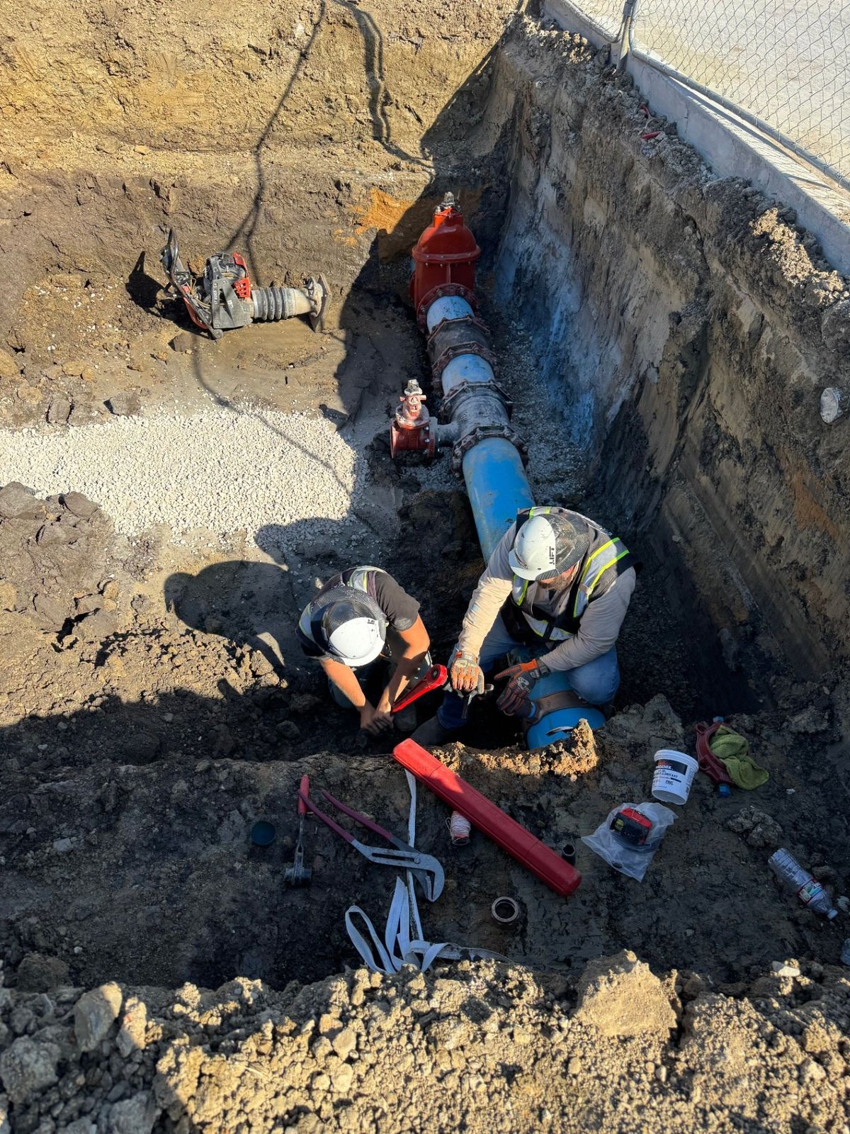 Crew assembling fireline pipe in open trench