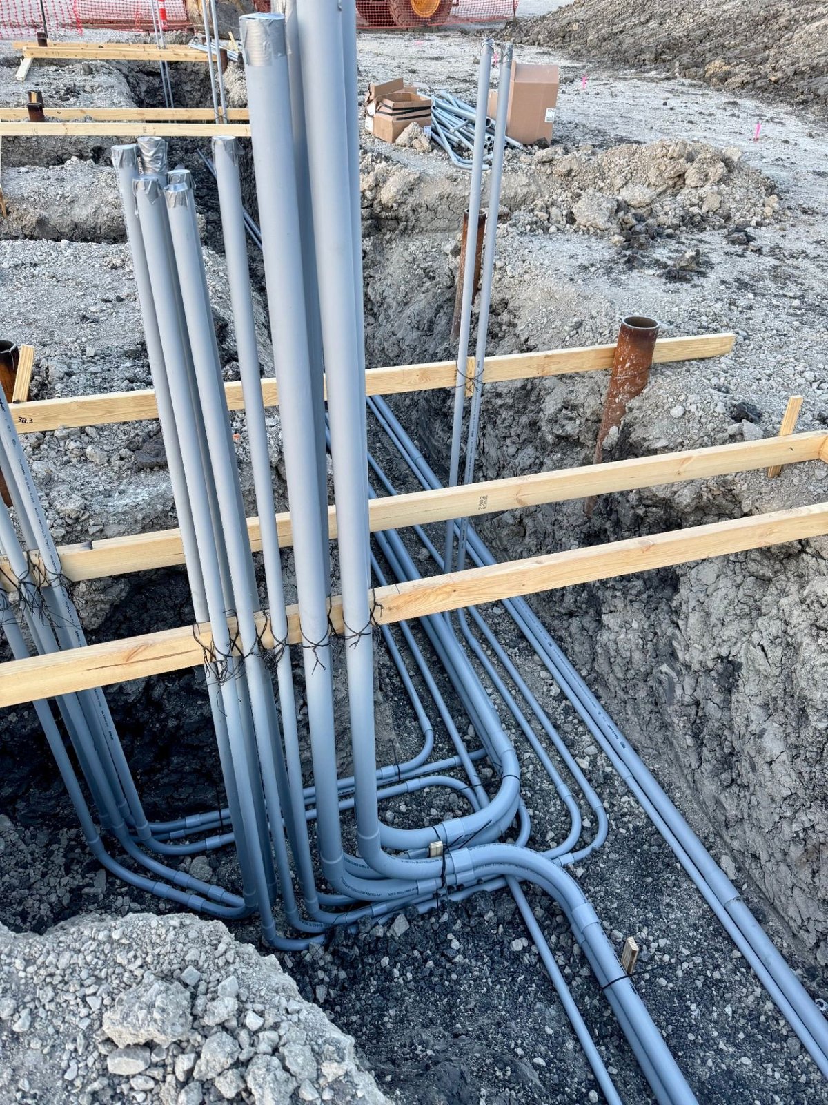 PVC conduit bends and risers braced in an open duct bank trench prior to concrete encasement