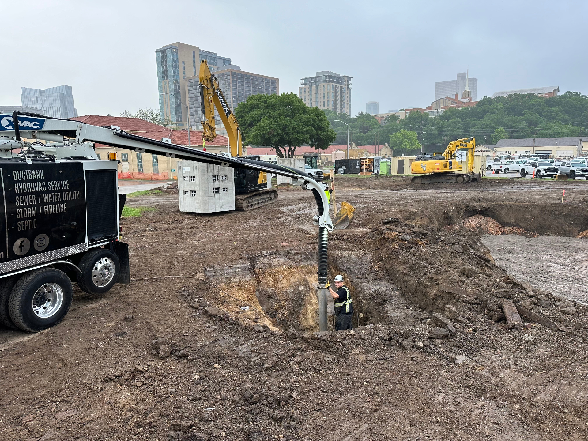 Hydrovac boom potholing near precast structures on a downtown construction site